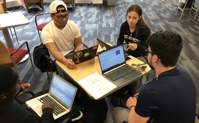 一组学生用笔记本电脑一起工作