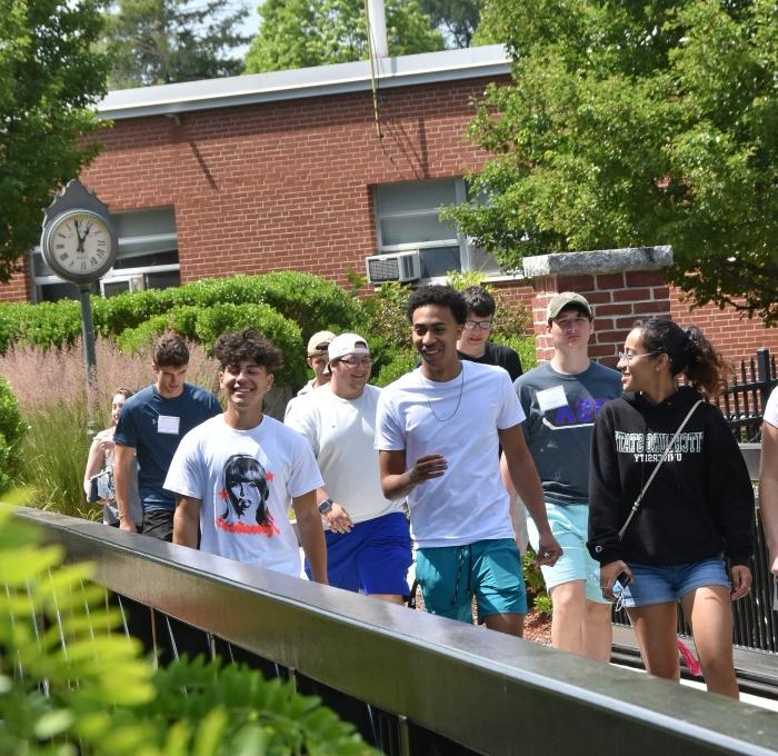 Happy group of students at orientation walking across bridge to Holmes