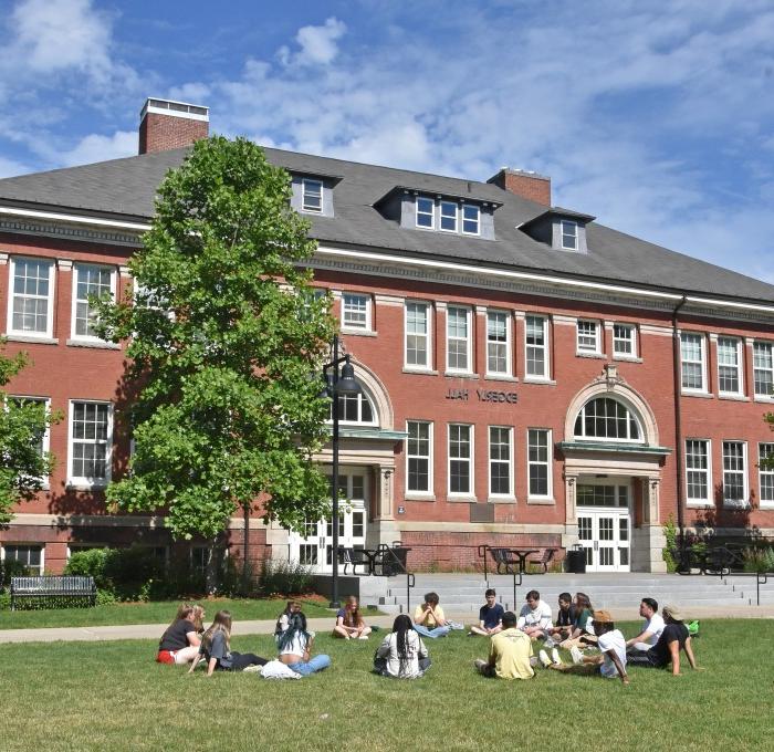 Group of students sitting in grass on the quad in front of Edgerly